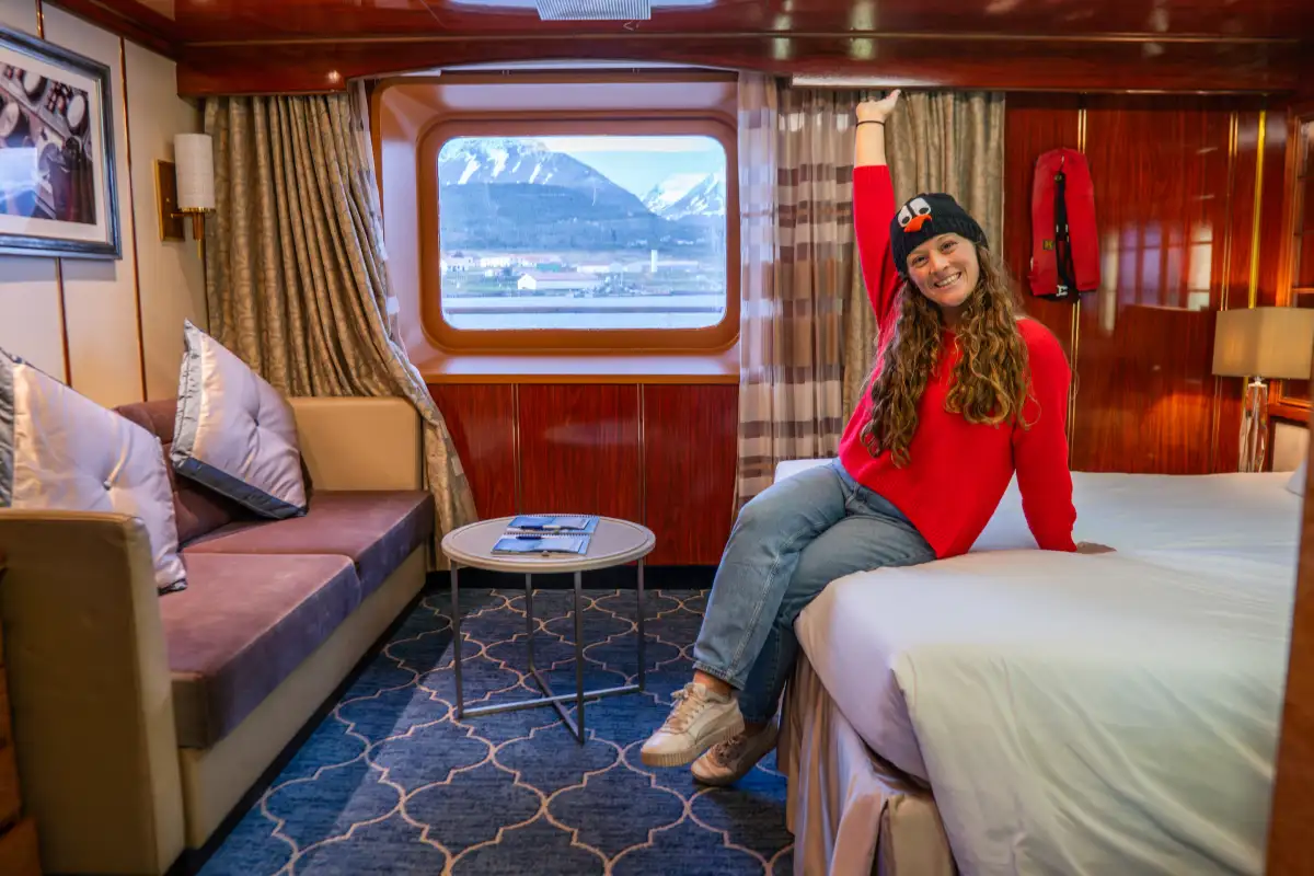 Modern cabin on an expedition cruise ship featuring panoramic windows and comfortable furnishings designed for small-ship adventure travel